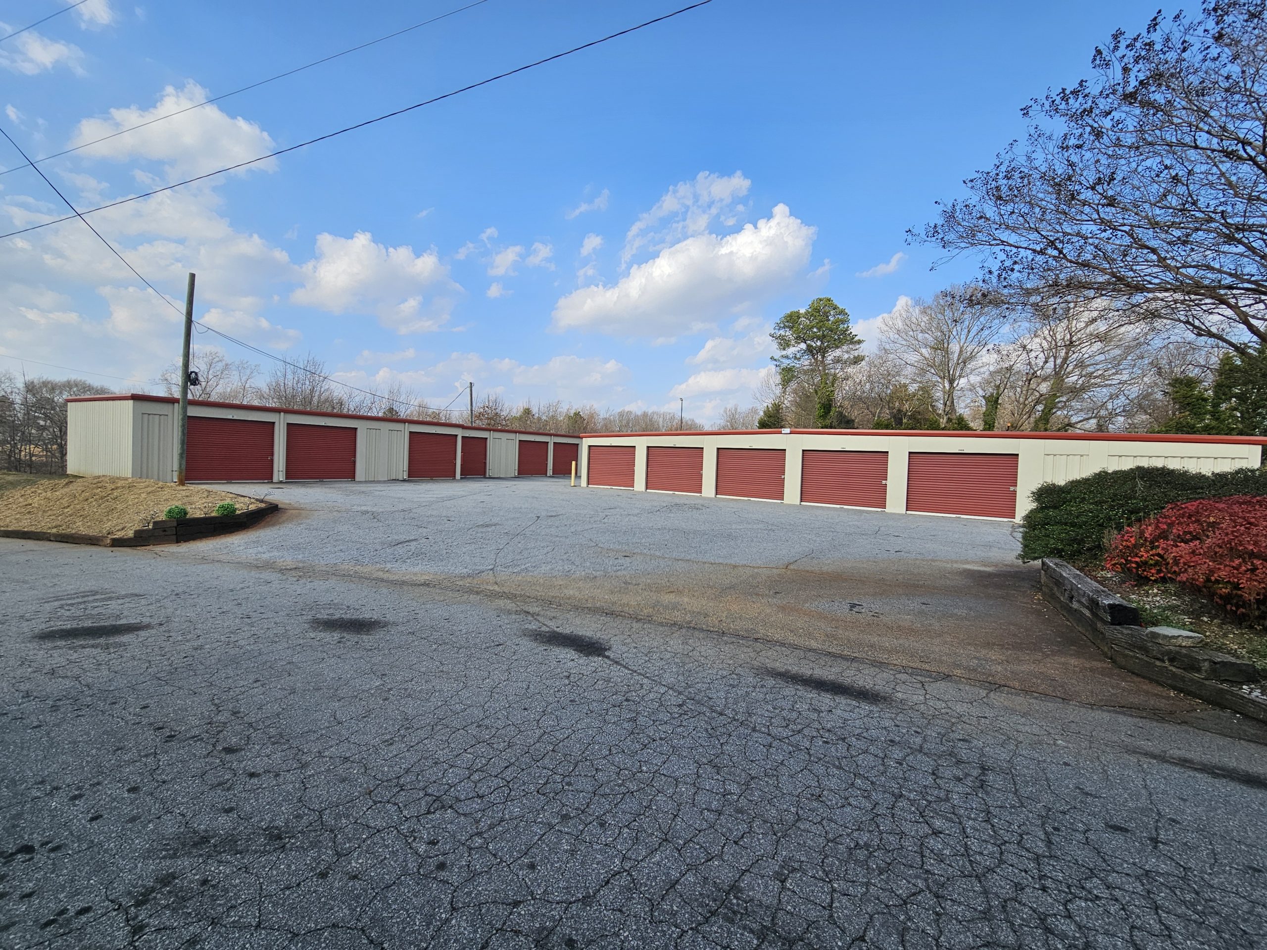 Perimeter view of outdoor self storage units with red doors