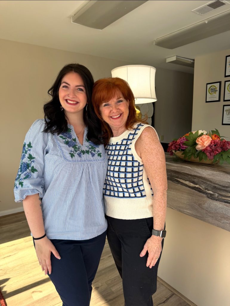 Two team members at Powdersville Self Storage smiling at the front desk